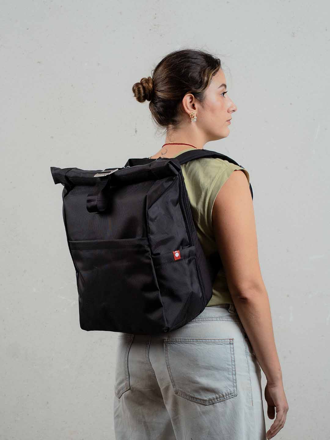 Mujer de espaldas usando morral enrollable de viaje Mont 24L